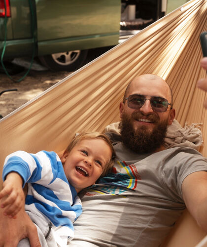 high-angle-man-taking-selfie-with-kid-hammock