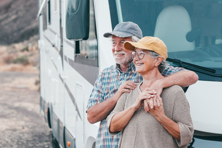 happy-senior-couple-leisure-trip-enjoying-travel-destination-standing-outside-camper-motorhome