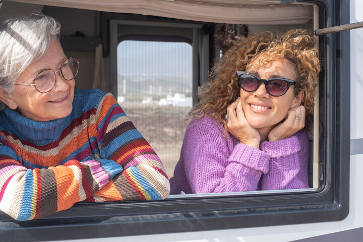 portrait-attractive-happy-caucasian-friends-women-traveling-camper-van-motor-home-looking-out