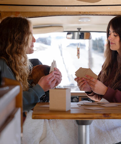 two-female-playing-cards-during-winter-trip