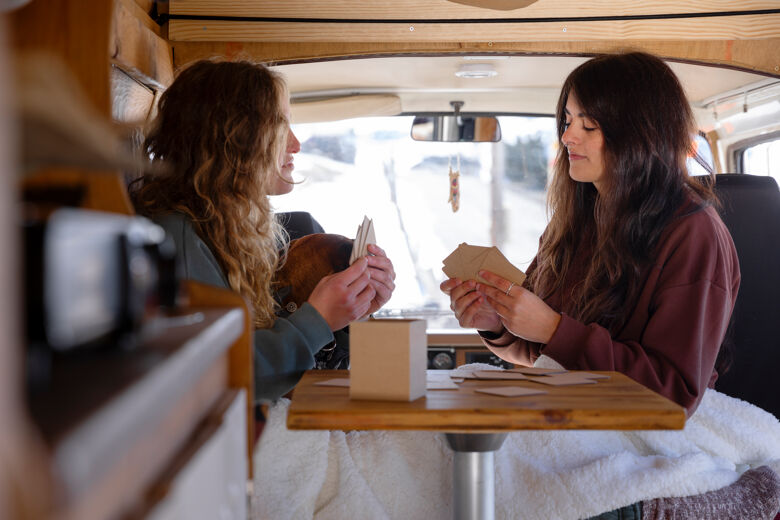 two-female-playing-cards-during-winter-trip
